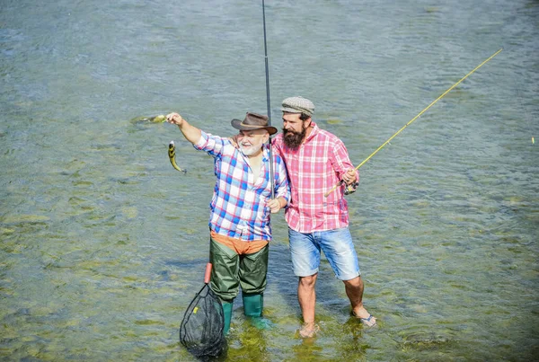 Wspólna praca to sukces. rybak z wędką i siecią. hobby i aktywność sportowa. Przynęta na pstrągi. Letni weekend. dojrzali mężczyźni wędkarze. ojciec i syn łowią ryby. męska przyjaźń. tworzenie więzi rodzinnych — Zdjęcie stockowe