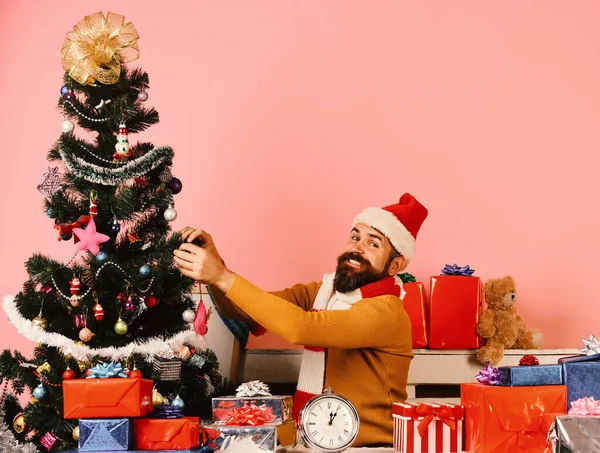 Santa decorates Christmas tree. Santa Claus sits near fir tree — Stock Photo, Image