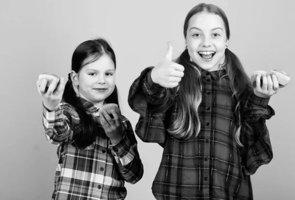 Deliciosas magdalenas. Chicas lindos niños comiendo magdalenas o magdalenas. Dulce postre. Receta culinaria. Sabroso bocadillo. Habilidad para cocinar. Las hermanas sostienen magdalenas horneadas. Comida casera. Alimentación saludable y calorías —  Fotos de Stock