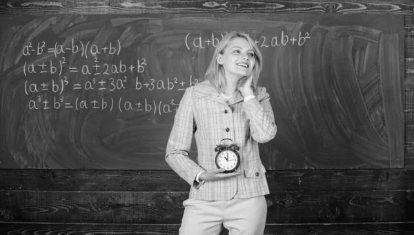 Lessons schedule. Welcome teacher school year. Experienced educator start lesson. She cares about discipline. Woman teacher hold alarm clock. Girl formal wear school lecturer. What time is it — Stock Photo, Image