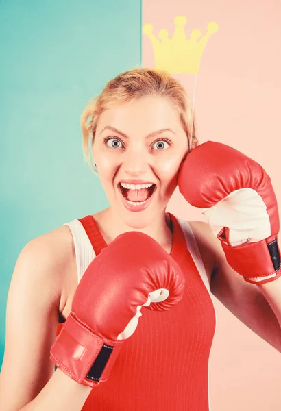 Workout done, have your fun. Cute boxer girl with party prop. Funny woman with crown prop in boxing gloves. Athletic woman in sports wear. Sportswoman with princess look. Boxing is fun for her