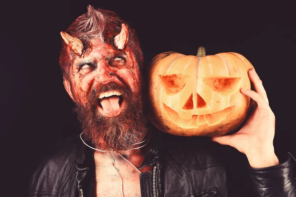 Halloween party concept. Man wearing scary makeup holds pumpkin — Stock Photo, Image