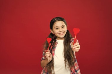 Seni seviyorum demek için bir gün bu. Sopa üzerinde kalpler veren küçük kız. Küçük kırmızı kalpler ile şirin kız. Küçük çocuk kalp süslemeleri şeklinde. Sevgililer günün kutlu olsun. Tatil aşk ve romantizm