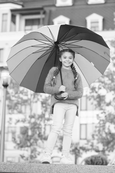 Me siento caliente. Niño optimista y alegre. Primavera caliente. Humor positivo en el clima cálido de otoño. Paraguas multicolor para niña feliz. Niña bajo paraguas colorido. Arco iris después de lluvia — Foto de Stock