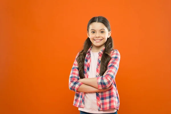 Confident girl. kid long hair. small girl checkered shirt. happy child. happy childrens day. childhood memory. little girl orange background. kid fashion. smiling school girl. copy spac — 스톡 사진