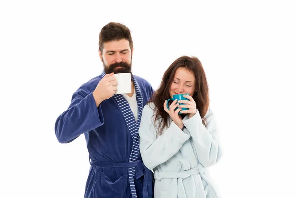 カップルは怠惰な週末を楽しみ、コーヒーを飲む。男性と女性はバスローブを着てティーマグカップやコーヒーカップを保持します。カフェインパワーコンセプト。コーヒーの朝は味がいい。カップルはコーヒーと朝リラックス — ストック写真