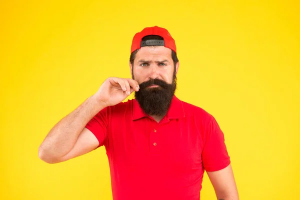 Mi sento benissimo. Guida alla toelettatura dei baffi. Hipster bel ragazzo che tocca i baffi. Consigli per crescere e mantenere i baffi. Uomo hipster barbuto torcendo baffi sfondo giallo. Salone di barbiere — Foto Stock