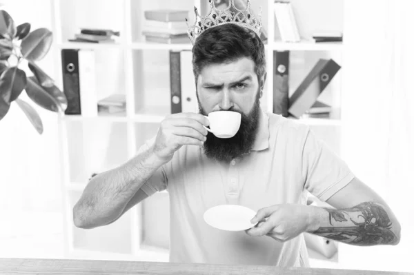 Relaxed top manager drinking coffee. Confident boss enjoying his glory. King of office. Head of department. Head office concept. Man bearded manager businessman entrepreneur wear golden crown on head