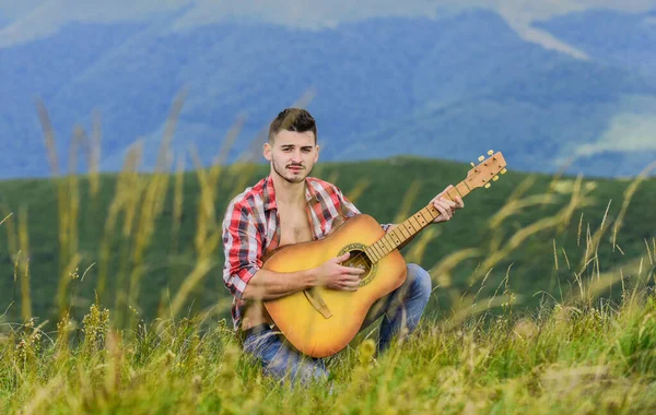 Εμπνευσμένο περιβάλλον. Άντρας με κιθάρα στην κορυφή του βουνού. Ακουστική μουσική. Θερινό φεστιβάλ μουσικής σε εξωτερικούς χώρους. Παίζοντας μουσική. Ο ήχος της ελευθερίας. Εμπνευσμένος μουσικός παίζει ροκ μπαλάντα. Σύνθεση μελωδίας — Φωτογραφία Αρχείου