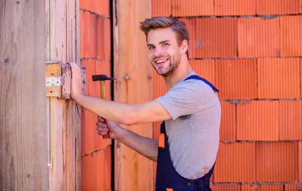 Master of building at work. building and construction. engineer build house. architect repair and fix. man builder in work clothes. worker brick wall background. professional repairman hard hat