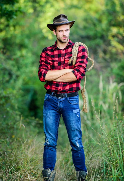 Cowboys är gentlemän. vilda västern rodeo. man i hatt utomhus. Man rutig skjorta på ranch. En man i vintagestil. Vilda västern retro cowboy. cowboy med lassorep. Västra. Västra cowboyporträttet — Stockfoto