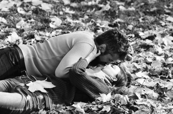 Homme et femme aux visages romantiques sur l'herbe et les feuilles — Photo