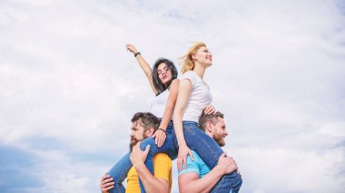 Hayatın tadını çıkarıyorum. Aşık oyuncu çiftler bulutlu gökyüzünde gülümsüyor. Sevgi dolu çiftler birlikte eğlenirler. Sevgi dolu çiftler açık havada eğlenceli aktiviteler yapıyor. Mutlu erkekler kız arkadaşlarını sırtlı