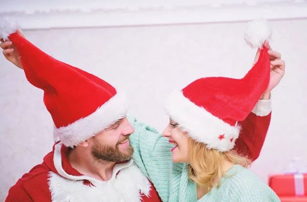Par i kärlek njuta av julfirande. Par bär hattar som jultomten julgran bakgrund. Det är lätt att sprida glädje runt. Lycklig familj firar jul. Jul gåva koncept — Stockfoto