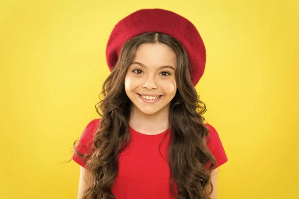 Infancia. peluquería. moda de verano y belleza. niño parisino sobre fondo amarillo. chica feliz con el pelo rizado largo en boina. Niña en sombrero de estilo francés. Retrato de moda de niña —  Fotos de Stock