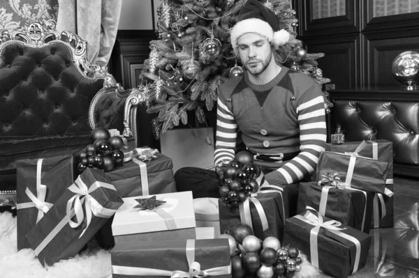 Presentes Elfmade são os melhores. Homem feliz com caixas de presente de ano novo. O tipo está a celebrar o ano novo em casa. Homem em Santa chapéu segurar presentes de ano novo. Feliz Natal e Feliz Ano Novo — Fotografia de Stock