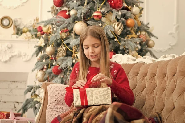 Een lintje strikken. Boksdag is de dag na Kerstmis. Meisje met geschenkdoos. Gelukkig kind viert kerst en nieuwjaar. Kind meisje voor te bereiden op boksdag vakantie. Gelukkig nieuwjaar — Stockfoto