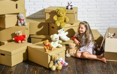 Tatil için eve geldim. Yeni bir yaşam alanı satın almak. Yeni evimizde oynuyoruz. Yeni daire. Karton kutular yeni eve taşınıyor. Oyuncağı olan mutlu küçük bir kız. Mutlu çocuk karton kutu