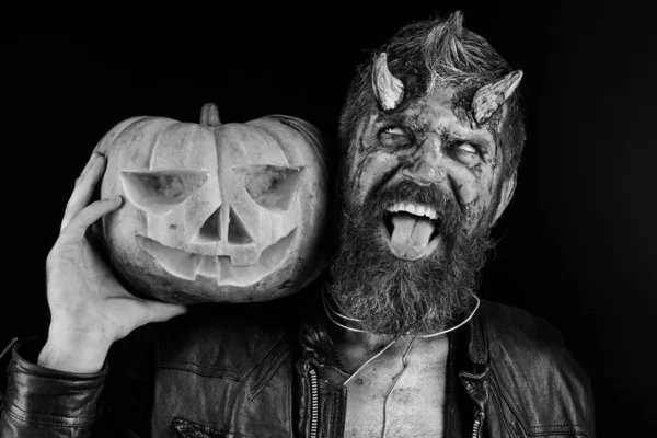 Концепция вечеринки на Хэллоуин. Человек в страшном макияже держит тыкву — стоковое фото