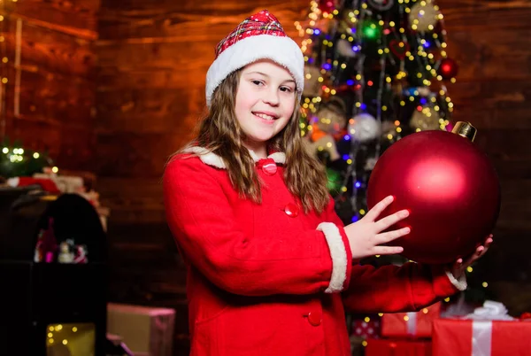 Chica traje de Santa Claus celebrar grandes adornos árbol de navidad bola. Decoraciones navideñas. Decora todo a tu alrededor. Juguete brillante. Me encanta decorar el árbol de Navidad. Ambiente festivo día de Navidad —  Fotos de Stock