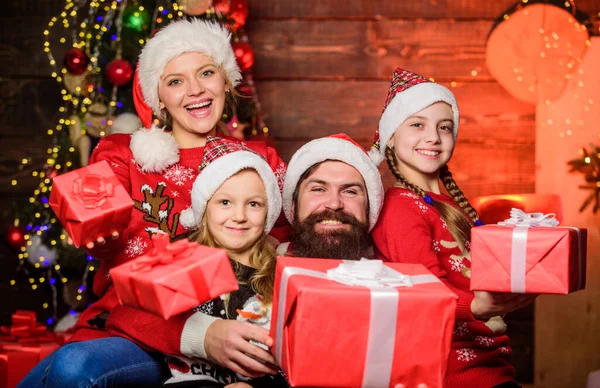 Padres e hijos abriendo regalos de Navidad. Padre Santa Claus y madre hijas pequeñas fondo del árbol de Navidad. Tradición navideña. Un concepto familiar alegre. La alegría de Navidad. Felices fiestas —  Fotos de Stock