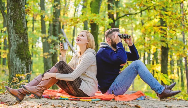 Parktermin. Gemeinsam im Park entspannen. glückliches Liebespaar entspannt sich im Park zusammen. verliebte Touristen entspannen auf einer Picknickdecke. Mann mit Fernglas und Frau mit Metallbecher genießen Naturpark — Stockfoto