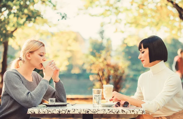 Female leisure. Girls friends drink coffee talk. Conversation women cafe terrace. Friendship friendly relations. Discussing rumors. Trustful communication. Friendship sisters. Friendship meeting