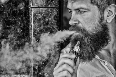 Sakallı adam duman dışarı nefes. Elektronik sigara sigara. Stres Rölyef kavramı. Sigara cihazı. Adam uzun sakal sigara alışkanlığı ile rahat. Aromalı duman bulutları. Sakallı adam sigara vape