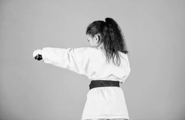 Schopnosti sebeobrany. Karate dává pocit důvěry. Silné a sebevědomé dítě. Je nebezpečná. Malá holčička v bílém kimonu s pásem. Bojovník karate připravený bojovat. Sportovní koncepce karate — Stock fotografie