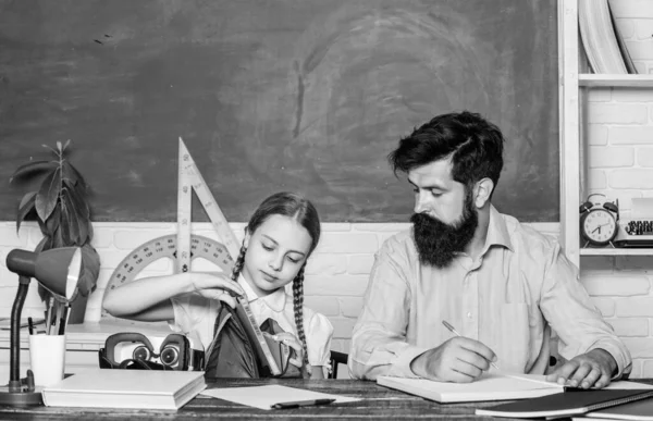 what is insedi. daughter study with father. Teachers day. knowledge day. Home schooling. back to school. Private teaching. small girl child with bearded teacher man in classroom. private lesson
