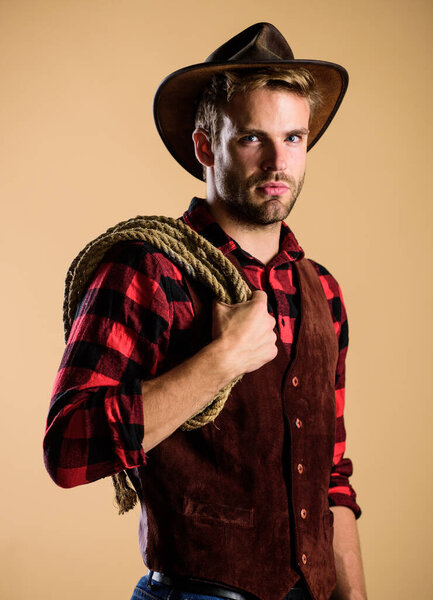 real man. Vintage style man. Wild West retro cowboy. cowboy with lasso rope. Western. wild west rodeo. man in hat. man checkered shirt on ranch. western cowboy portrait