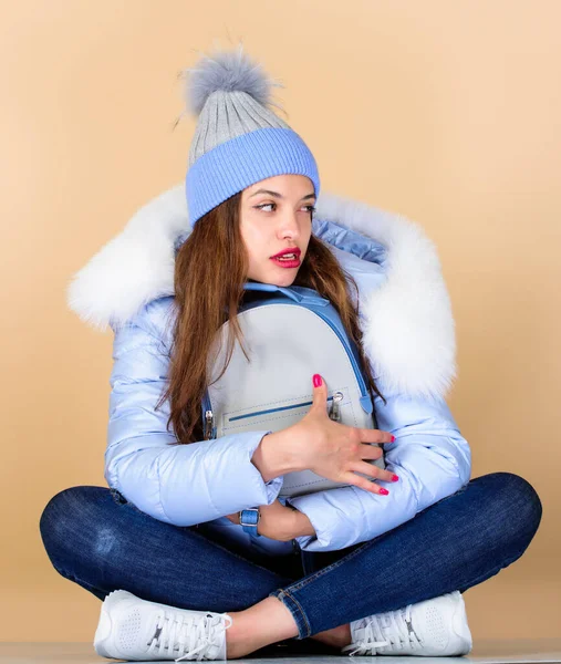 this is mine. happy winter holidays. woman in beanie hat with backpack. flu and cold season. Leather bag fashion. warm winter clothing. shopping. girl in puffed coat. faux fur fashion