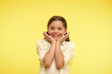 Gülen bebek. Heyecan dolu. Kız mutlu güler yüz onun yanakları sarı arka plan dokunur. Öğrenci bir şey hakkında heyecanlı. Çocuk şirin çocuk heyecanlı hissediyorum. Çok şirin. Mutluluk çocukluk