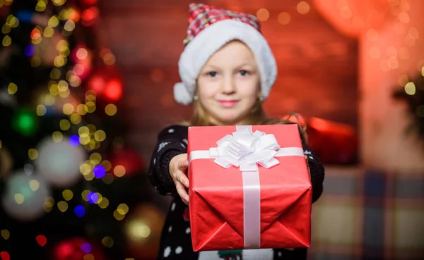 Nada calienta el corazón como dar un regalo de Navidad. Feliz niña dando regalo de Navidad. Niño pequeño sosteniendo presente en el día de Navidad. Adorable niño con regalo de Navidad bellamente envuelto —  Fotos de Stock