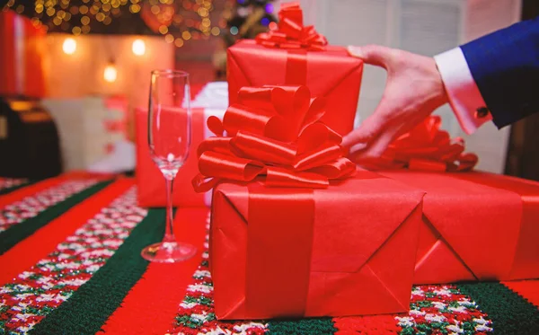 クリスマスと新年に備えます。ラッピング ギフトのコンセプトです。魔法の瞬間。家族や友人のための驚きの贈り物を準備します。大きなリボンの弓でギフト ボックスをクローズ アップ。赤の贈り物をラップやプレゼント — ストック写真