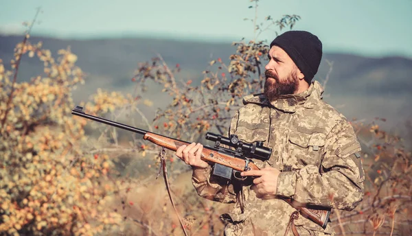 Hunting equipment for professionals. Hunting is brutal masculine hobby. Man aiming target nature background. Hunter hold rifle. Aiming skills. Hunting permit. Bearded hunter spend leisure hunting
