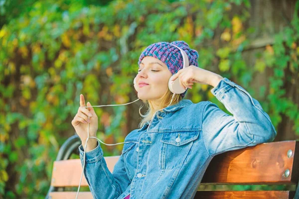 Feeling awesome. Cool funky girl enjoy music in headphones outdoor. Girl listen music in park. Melody sound and mp3. Music fan concept. Headphones must have modern gadget. Enjoy powerful sound