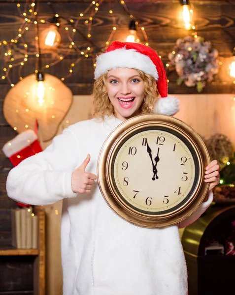 时间管理。圣诞节的气氛。女人的钟表。新年快乐。圣诞节的准备工作。寒假。是时候过圣诞节了。戴着红色圣塔爪帽的女孩。午夜。快乐的女人该庆祝了 — 图库照片