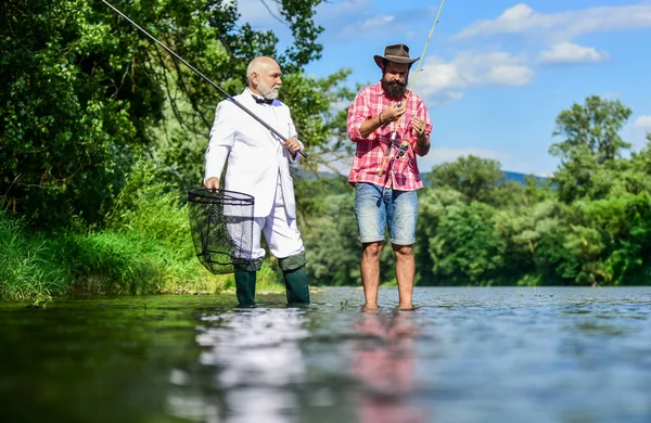 Perfect weekend. Hobby and recreation. Family day. Summer vacation. Friends fishing. Fishing as holiday. Fisherman in formal suit. Successful catch. Elegant bearded man and brutal hipster fishing