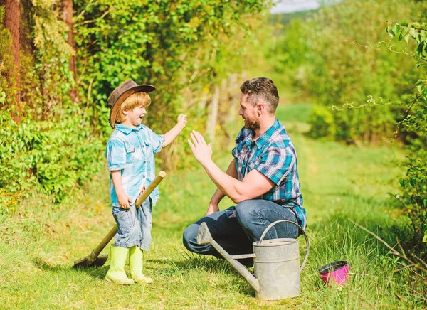 Small boy child help father in farming. use watering can and pot. Garden equipment. Eco farm. father son in cowboy hat on ranch. happy earth day. Family tree nursering. Put everything under control — Stock Photo, Image