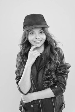 Hipster gibi. Sarı arka planda mutlu küçük hipster. Sevimli küçük hipster şık bir görünüm ile gülümseyen. Hipster tarzı kıyafet ve moda aksesuarı giyen sevimli kız çocuk