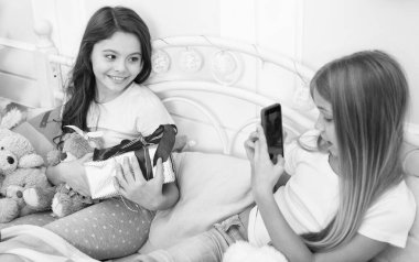 Video ve resimler gönderme. Cep telefonu ile mutlu küçük çocuklar. Küçük kız yatakta telefon kullanın. Smartphone ile Noel ve yeni yıl fotoğraf çekiyorum. Mutlu Noeller ve mutlu yeni yıl tebrik