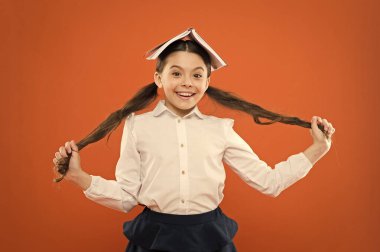 Bırak saçın kendi adına konuşsun. Turuncu arka plan üzerinde uzun esmer saç tutan sevimli küçük kız. At kuyruğu saç giyen baş kitap ile küçük bir okul çocuğu. Okul için saç şekillendirme ve saç bakımı