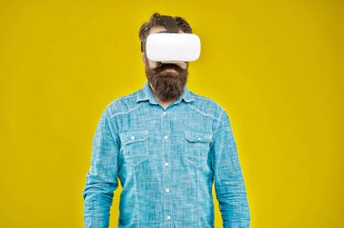 Gelecek düşündüğünden daha yakın. Sakallı adam VR sarı arka planını keşfetti. VR teknolojisi ve gelecek. VR iletişimi. Heyecan verici izlenimler. Hippi VR gözlüğü takıyor. Oyun ve eğlence