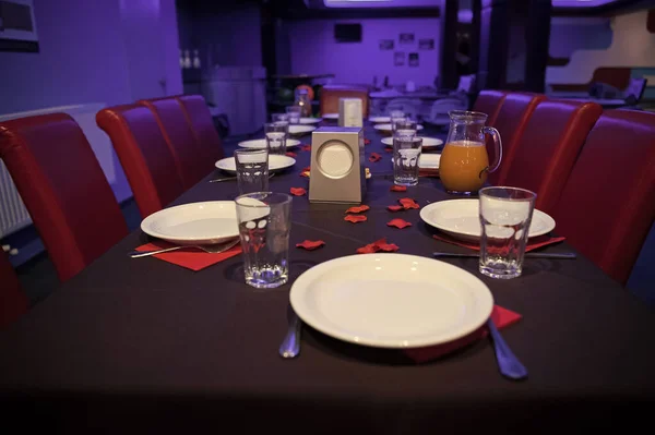 レストランのテーブルは、皿やコップを添えてください。カフェやレストランでのパーティーのために準備のテーブル。ケータリングやお祝いのコンセプトです。レストランで誕生日を祝います。家族での休暇や企業 — ストック写真