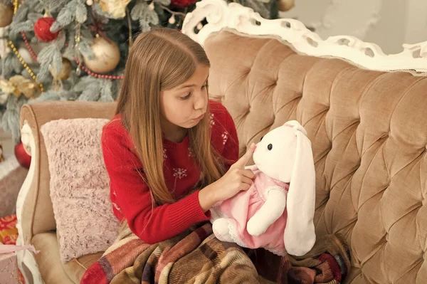Milczą. Mała dziewczynka przytrzymaj palec na ustach zabawka królik. Play małego dziecka przytulanka. Dziewczynka z cute bunny na choinkę. Małe dziecko z prezent na nowy rok. Najlepsza zabawka Christmas — Zdjęcie stockowe