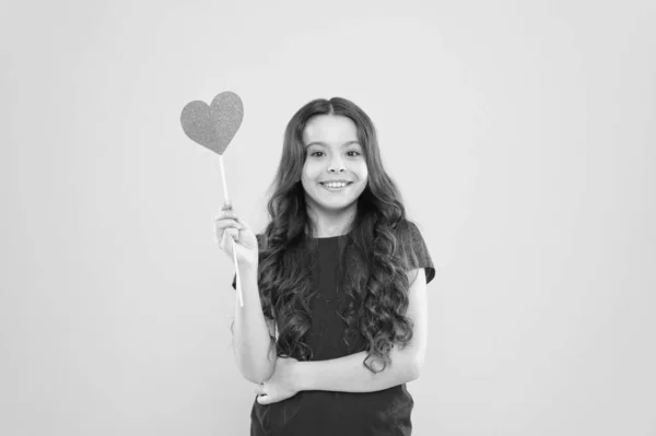 Te quiero. Te quiero. Niña pequeña sonriendo sostiene el símbolo del corazón en el palo. Me gusta y apoyo. Día de San Valentín. Enamórate. El amor salvará al mundo. Un chico promoviendo el amor. Actitud personal. Alegre humor —  Fotos de Stock