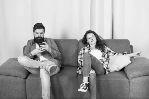 Мобильная зависимость гаджета. Мужчина бородатый хипстер играет на смартфоне в то время как подруга расслабляется рядом. Интернет-серфинг и социальные сети. Зависимость от мобильного интернета. Муж зависимый интернет-игры — стоковое фото