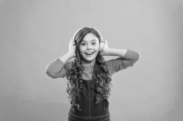 Sentindo a beleza da canção. Criança pequena bonito ouvir música no fundo azul. Menina adorável gostando de música tocando em fones de ouvido. Compor uma canção — Fotografia de Stock