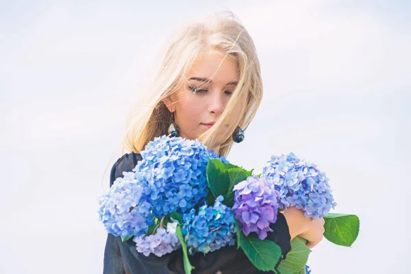 Cura della pelle e trattamento di bellezza. Fiore delicato per donna delicata. Bellezza pura. Dolcezza di pelle giovane. Fioritura primaverile. Ragazza tenera bionda tenere bouquet di fiori ortensia. Concetto di bellezza naturale — Foto Stock